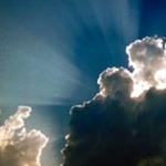 sun shining through dark clouds in the sky