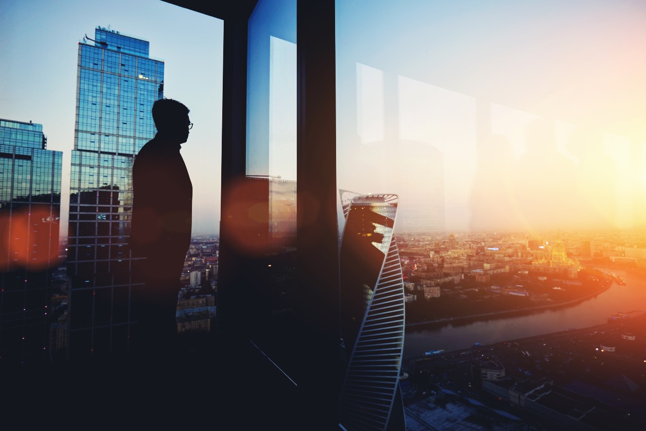 Man looking out of skyscraper window